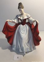 Front view of Royal Doulton Sara figurine showing detailed features and red-and-white dress.