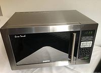 Front view of stainless steel Sanyo microwave with closed door, digital display showing 10:39 and keypad on the right.