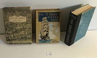Front view of three books: Out of Africa, In a Deep-Water Ship, The Silver Chalice