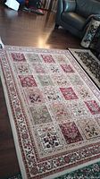 Full view of the Radiance Persian style area rug showing the entire rectangular shape placed on a hardwood floor with multi-colored floral grid patterns.