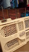 Close-up of Safety 1st Swing 'N Lock baby gate showing honeycomb pattern and locking handle.