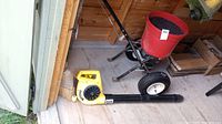 Yellow Paramount PB100C-50 electric blower lying on wood floor with black tube, fan outlet visible