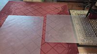 Two clear plastic chair mats placed on a carpeted floor showing overall size and shape.