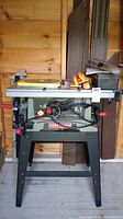 Front view of Craftsman table saw on black metal stand with power cord and adjustment wheels