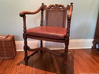 Front view of oak caned armchair with leather cushion