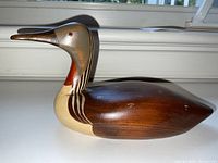 Side angled photo showing the detailed painting and wood grain of the Red Throated Loon decoy