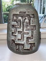 Front view of the vase showing the incised geometric pattern and gray matte finish.