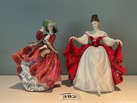 Front view of both figurines side by side on display surface