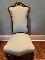 Front view of the Victorian slipper chair showing fabric and wooden frame.
