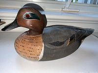 Side view showing detailed paintwork on head, eye, chest and wings, with minor scratches.