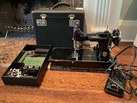 Singer machine removed from case showing front and gold decal details alongside accessories tray and foot pedal