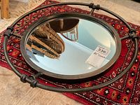 Top angled view of wrought iron framed mirror showing thickness and knotted iron details.