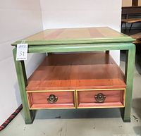 Front view of colorful stained wood end table showing green frame, orange shelf, and large drawer with two pulls.