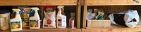 Shelf with assorted garden sprays and fertilizers including Take Down Garden Spray and Monterey Garden Insect Spray, Earthworm fertilizer bag, Jobes Organics Vegetable & Tomato Granular Plant Food.