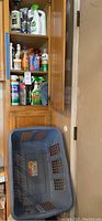Cabinet with multiple cleaning supplies including sprays and wipe containers. Items like Seventh Generation, Clorox, Method, Bona, and others visible.