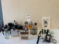 Full view of 14 assorted men's perfume bottles and 2 watches with original case, displayed on table.