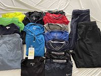 Overview of men's workout tops and shorts in multiple colors showing various Nike Pro Combat, Nike Dri-Fit items with a black and blue half zip tops and several crew neck shirts.