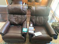 Front view of both brown leather recliners side by side