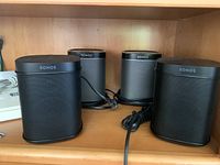Four black Sonos Play speakers on shelf
