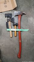 Full view of the four tools showing the large fire axe, two hatchets, and hammer.