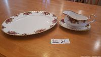 Turkey platter and gravy boat displayed on a wooden table with auction lot tag visible