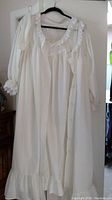 White full-length cotton nightgown with ruffled lace neckline and hem on hanger