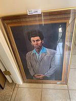 Framed Kramer portrait leaning against wall, showing full image and frame.