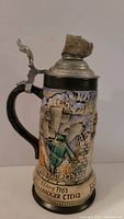 Side view of the stein showing a soldier climbing the Berlin Wall dated 13 Aug 1961 with Cyrillic inscription and the bottom rim inscription 'BERLINER MAUER'
