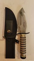 Full view of Humvee hunting knife and black nylon sheath with snap button closure.