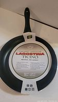 Photo of front side of Lagostina Ticino 12-inch skillet showing packaging and stirring hole in handle.