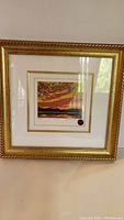 Framed sunset print with gold frame and double matting hung on a wall