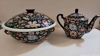 Photo showing the large Asian soup pot with lid and matching teapot together, highlighting the overall set and floral design.
