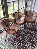 Three vintage caned chairs arranged facing outward, showing front and side views.