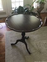Full view of the antique pie crust table showing the scalloped edge tabletop in a dark wood finish.