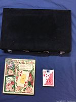 Closed black backgammon case with bridge cards and floral scorepad next to it