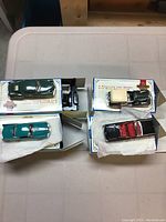 Four model cars shown in their original Matchbox boxes on a white table, top view