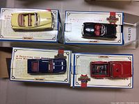 Four Matchbox classic model cars in original boxes displayed from a top view showing color and interior details.
