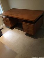 Front angled view showing two pedestal drawer cabinets, metal base and teak veneer finish