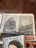 Photo showing souvenir coronation photos section with a large photo of a stone lion and nearby building, and two vintage magazines: Star Weekly and Weekend Picture Magazine