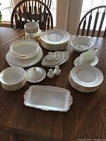 Full overview of stacks of plates, bowls and serving pieces on table