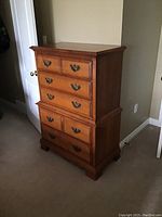 Full view of the tall wooden dresser showing drawer layout and condition.