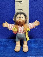 Full front view of the vintage Steiff Macki Hedgehog doll with tags, showing outfit and size measurements against ruler.