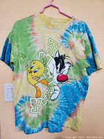 Front of t-shirt showcasing tie dye pattern and Sylvester & Tweety cartoon characters with "TWITTY" text.