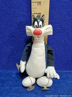Full body photo of the Sylvester plush toy showing suction cups on hands and feet and measurement ruler behind for size reference.