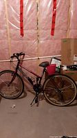 Full side view of red Raleigh Matterhorn bicycle showing frame, tires, handlebars, and rear carrier rack in partially finished basement area.