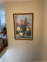 Front view of the large floral scene painting hung on a staircase wall, showcasing the ornate frame and the floral artwork.
