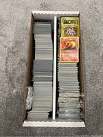 Overhead view of two-row cardboard box filled with sleeved Pokémon trading cards
