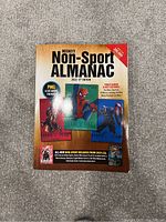 Photo of Beckett Non-Sport Almanac 2nd Edition 2020 softcover book showing front cover with price guide information and collectible card images.
