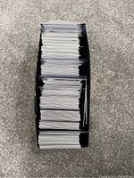 Top-down view inside the black trading card binder showing thick stacks of NBA basketball cards.