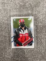 Close-up of a 2021 Formula 1 Topps trading card showing Kimi Räikkönen in Alfa Romeo Racing attire wearing a mask.